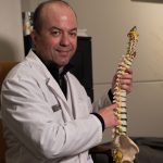 Man holding replica of a spine
