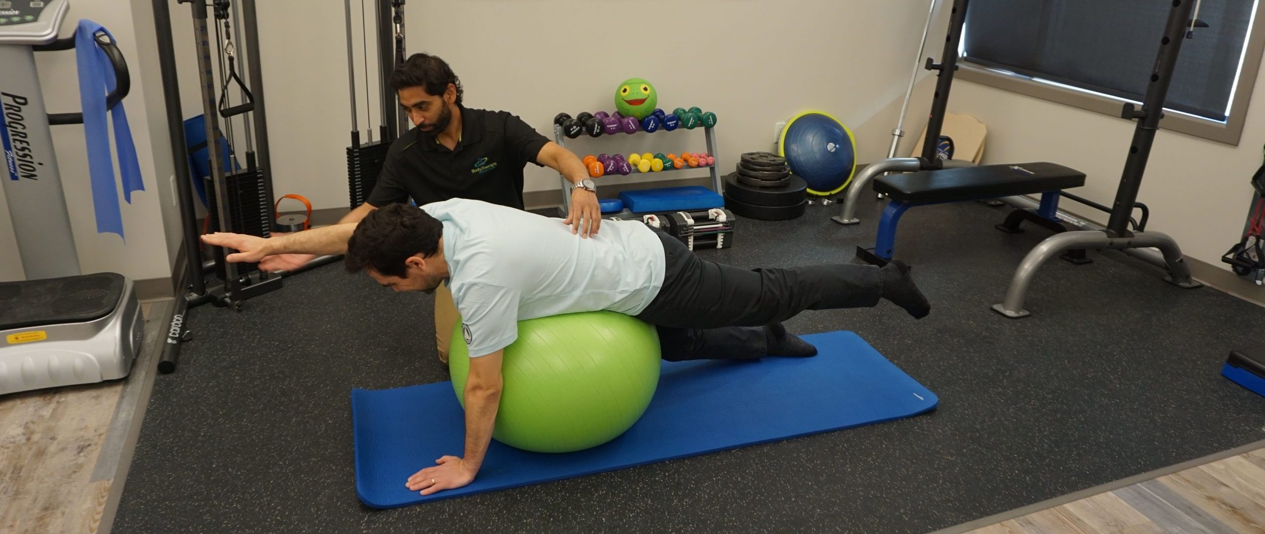 Physiotherapist helping patient with an exercise for their back